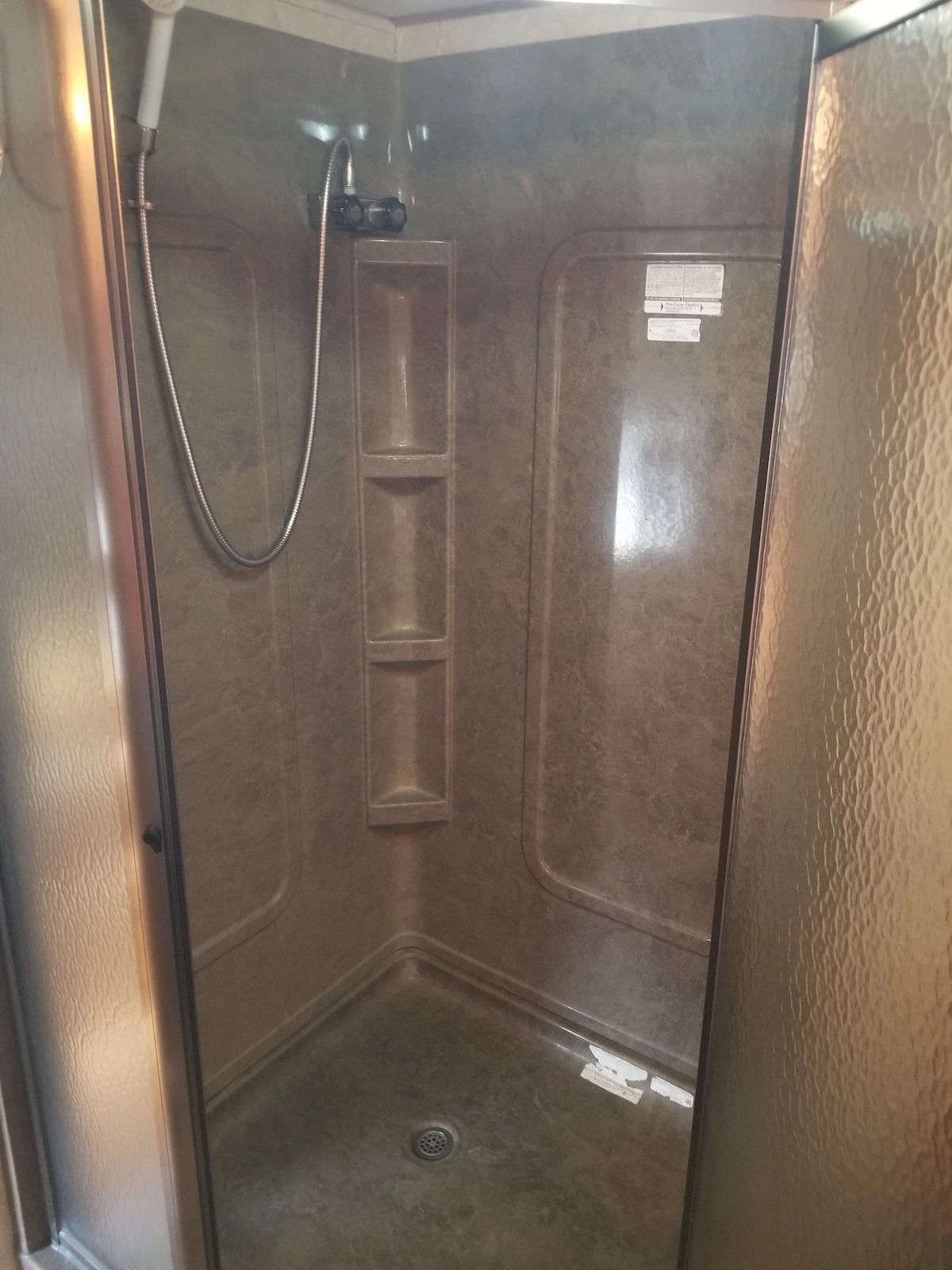 A shower stall with a glass door and a shower head.