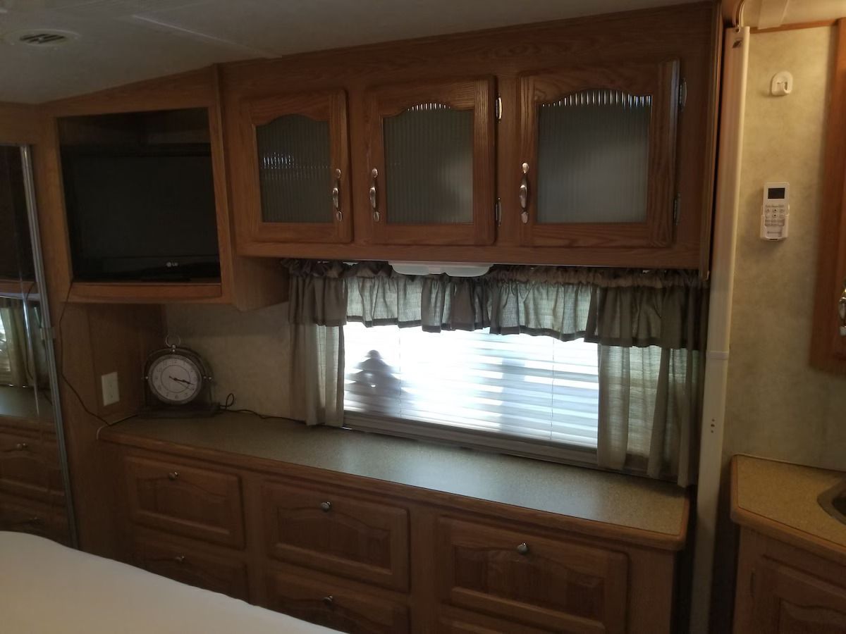 A bedroom with lots of cabinets and a window