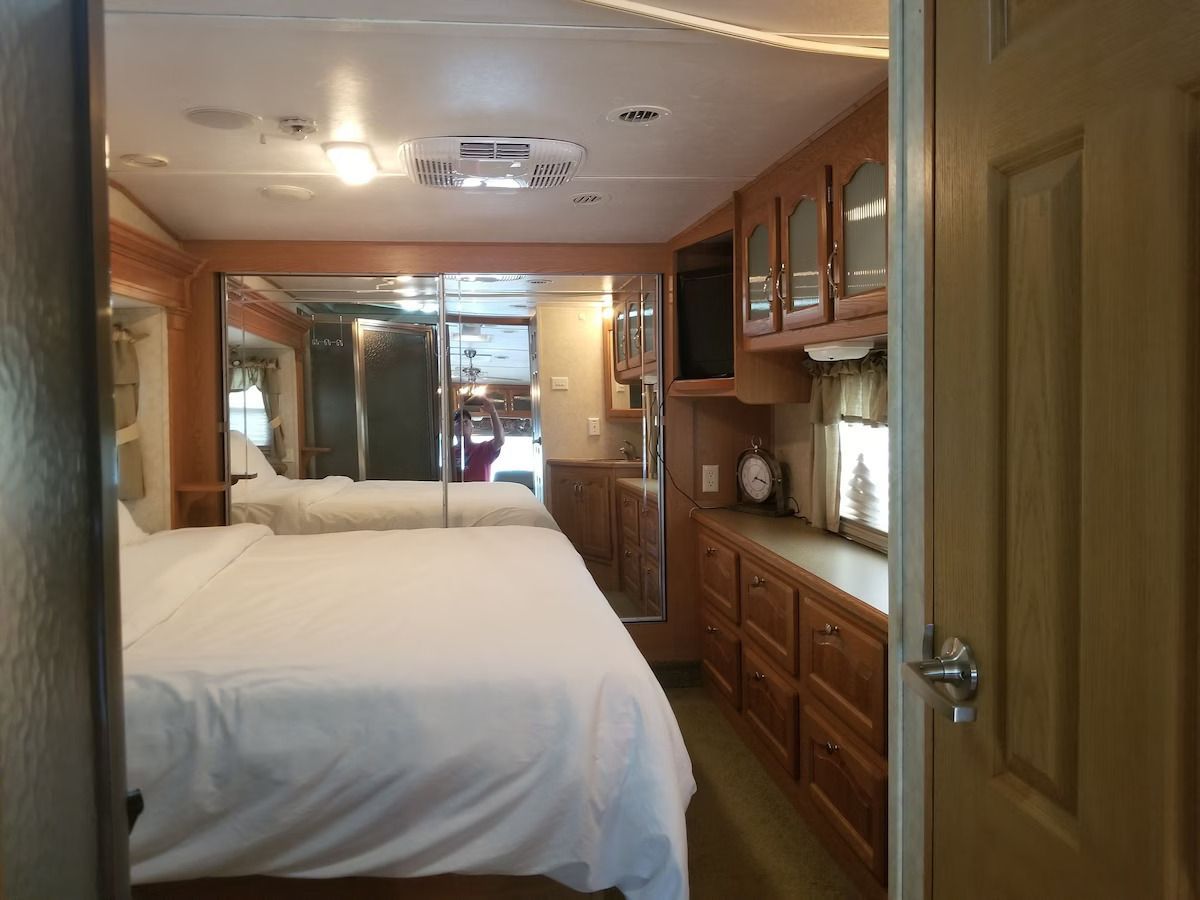 A bedroom in a trailer with a bed and cabinets