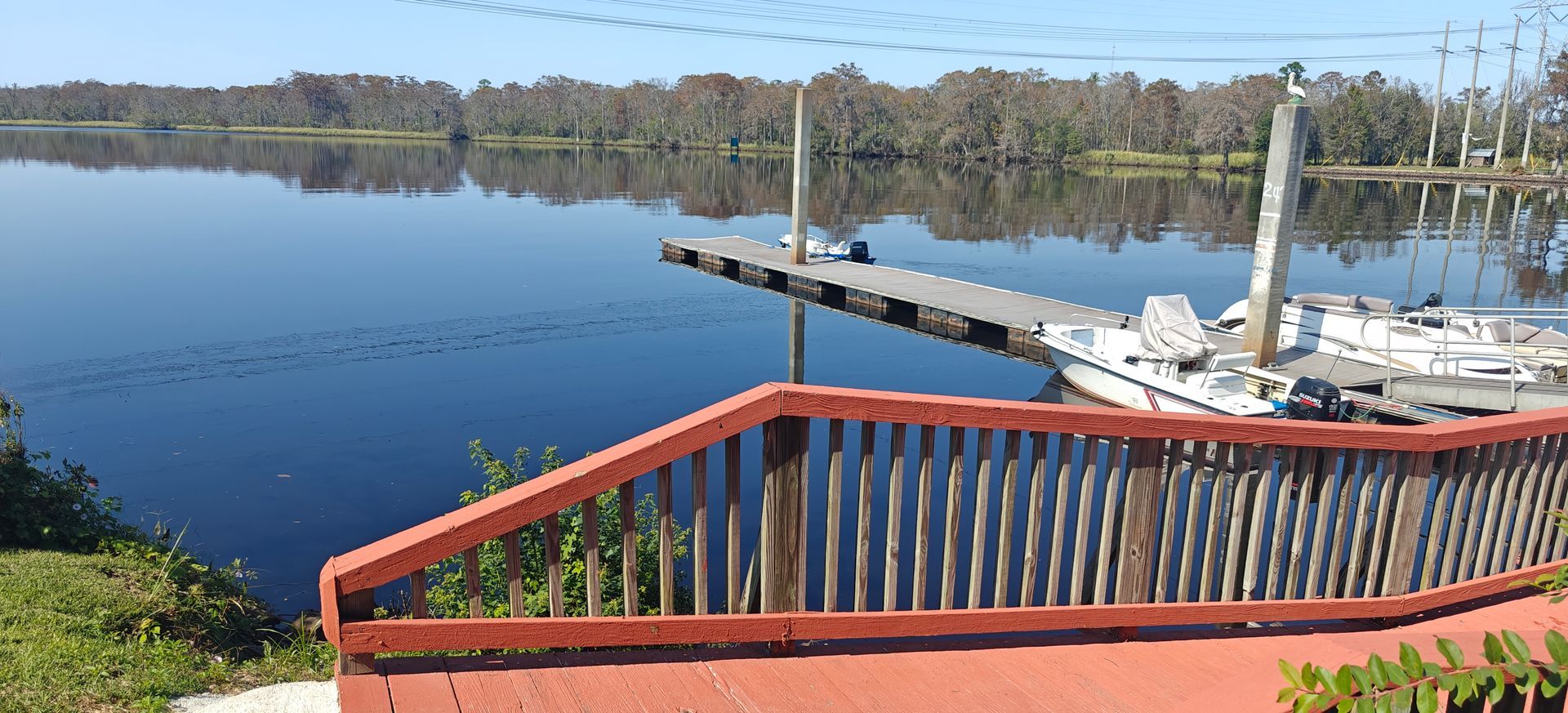 A boat is docked at a dock next to a red railing