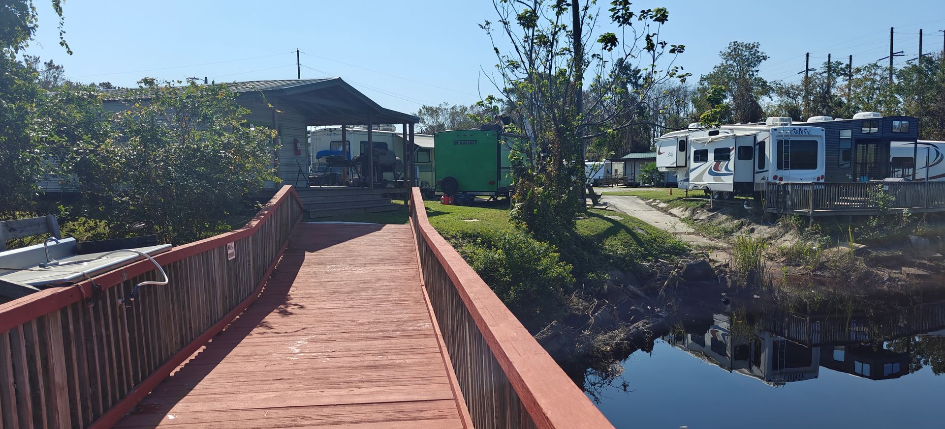A bridge over a body of water with a lot of rvs in the background.