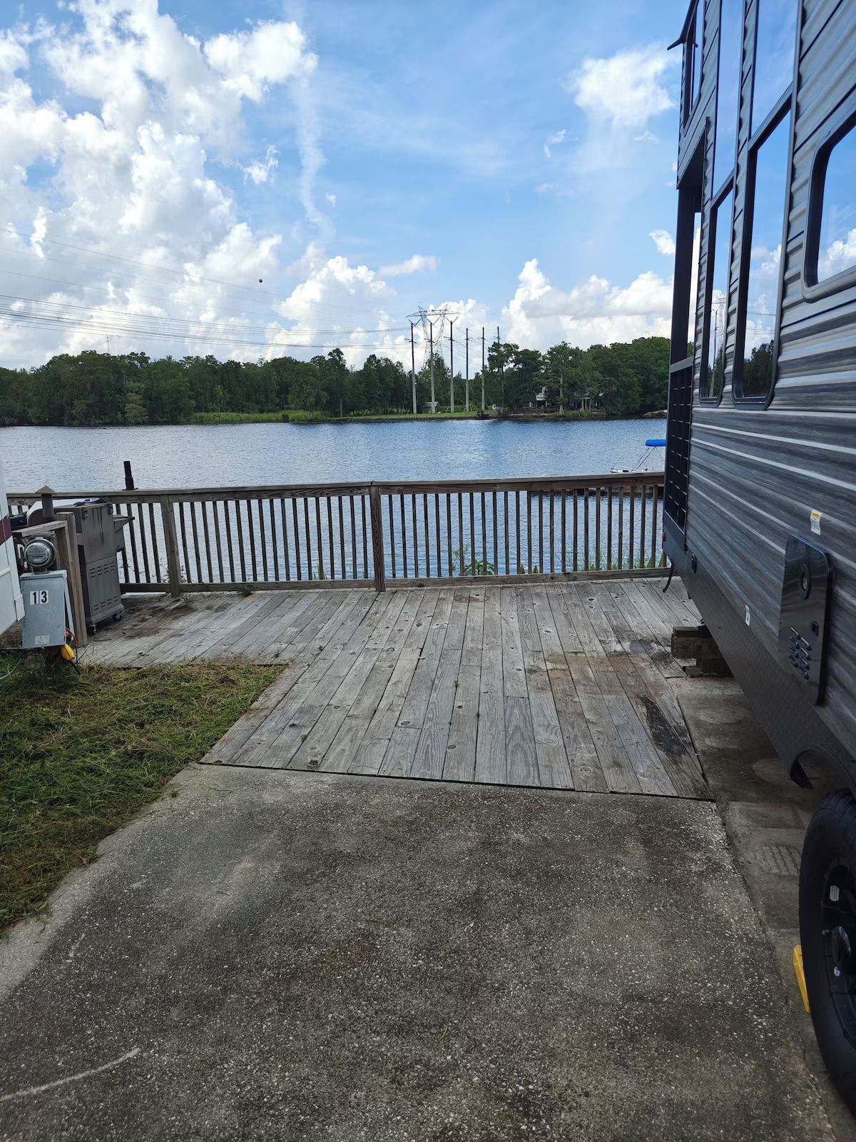 A rv is parked on the side of the road next to a lake.