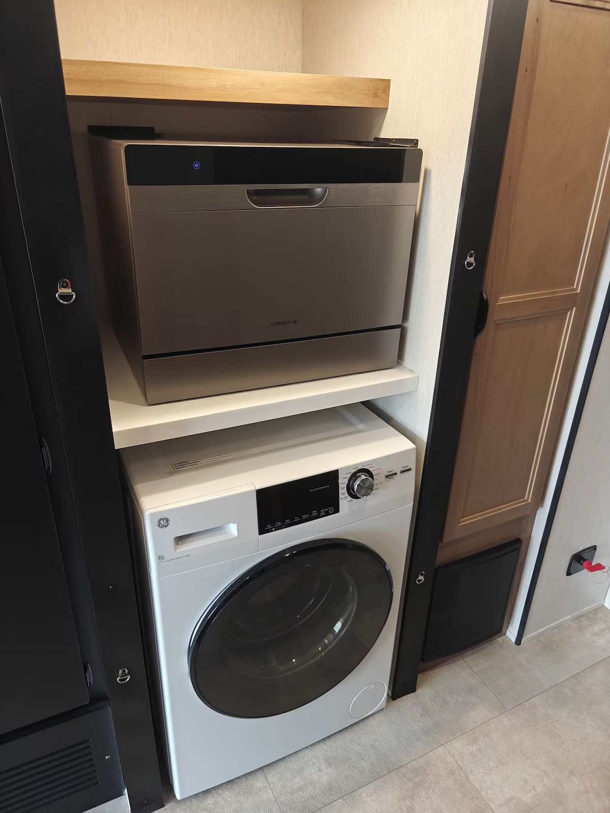 A washer and dryer are in a laundry room next to a dishwasher.