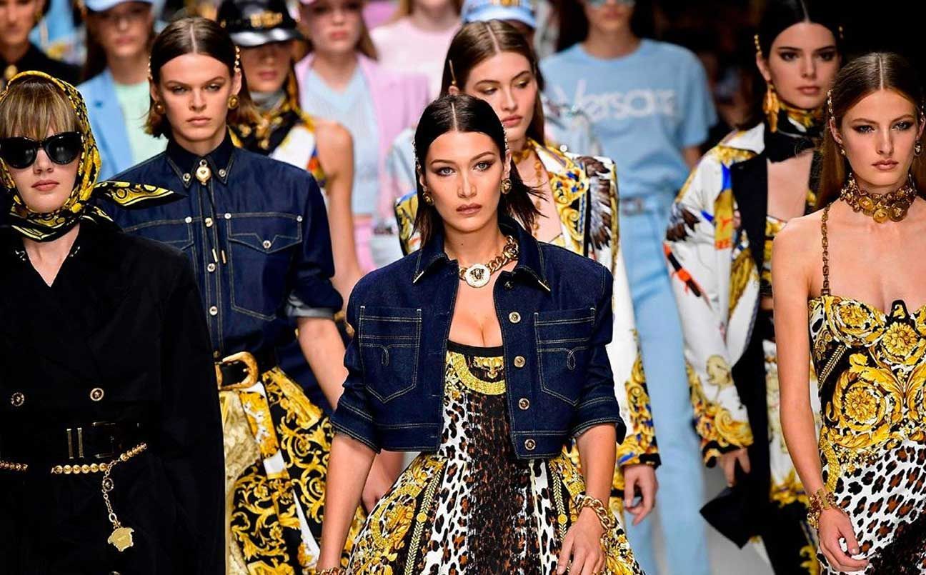Modelli in abiti a fantasia e giacche di jeans sfilano in una sfilata di moda.