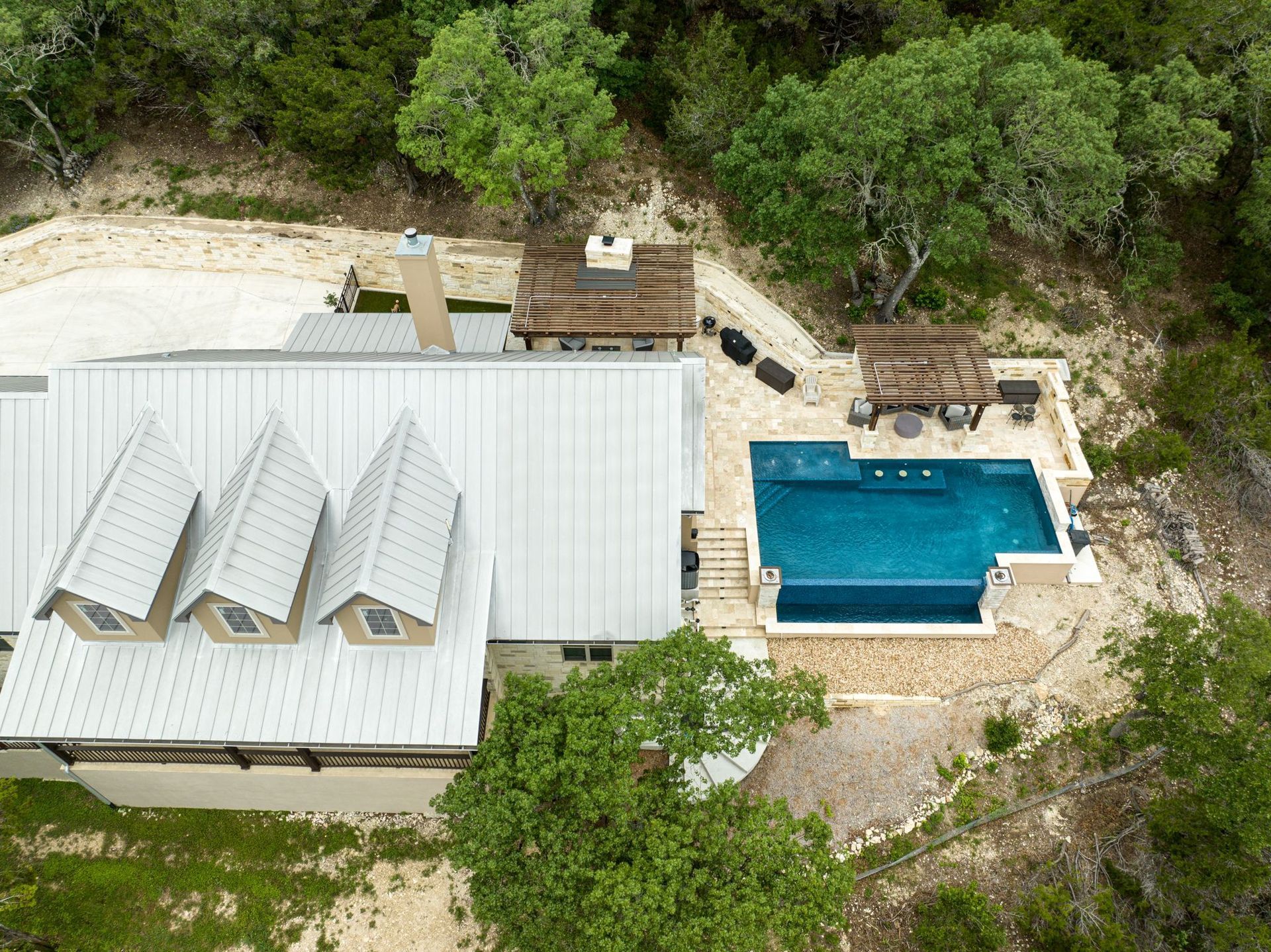 An aerial view of a house with a swimming pool built by Fine Patio Design n San Antonio TX