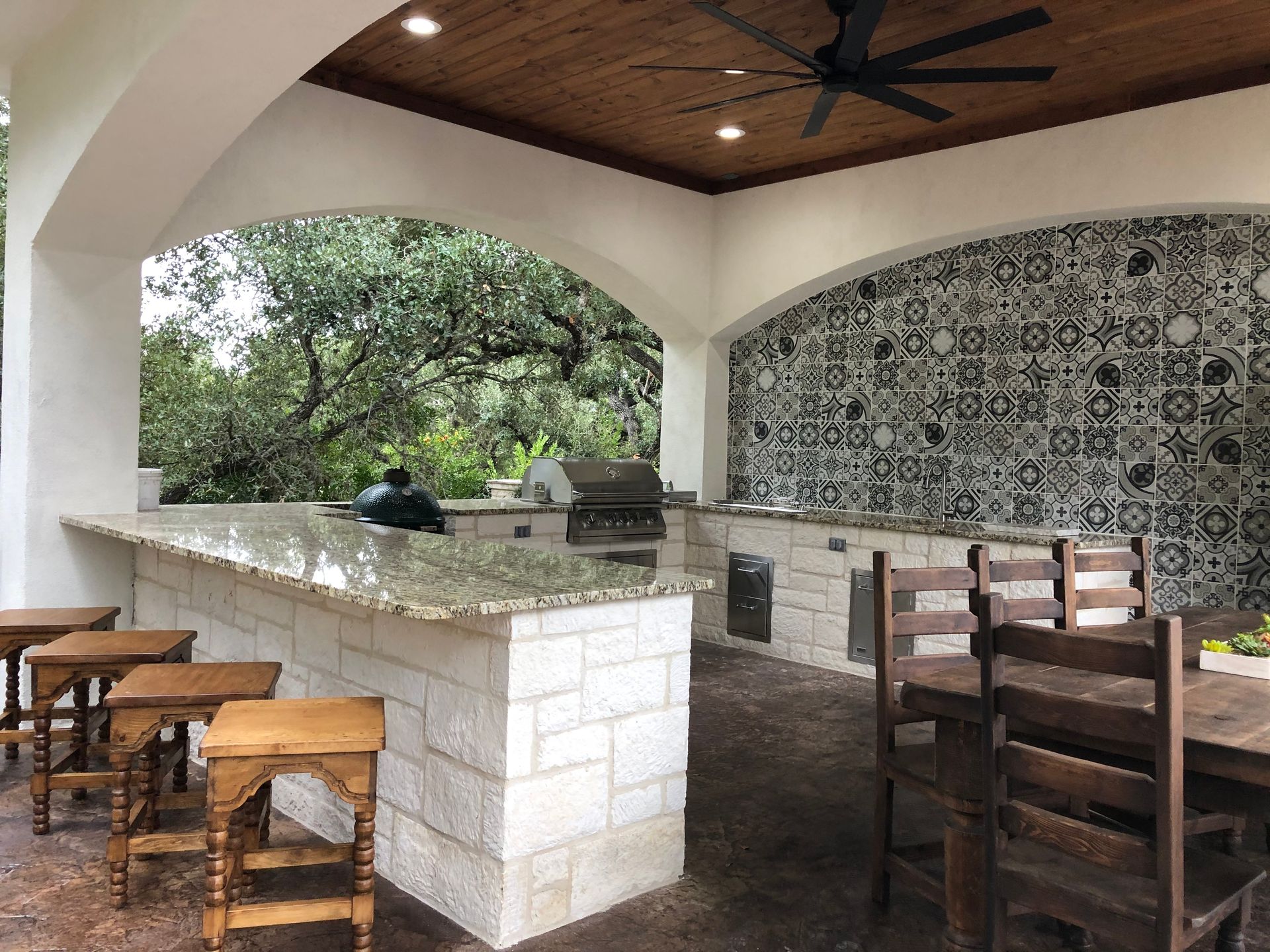 A patio with a ceiling fan and a table and chairs built by Fine Patio Design San Antonio TX