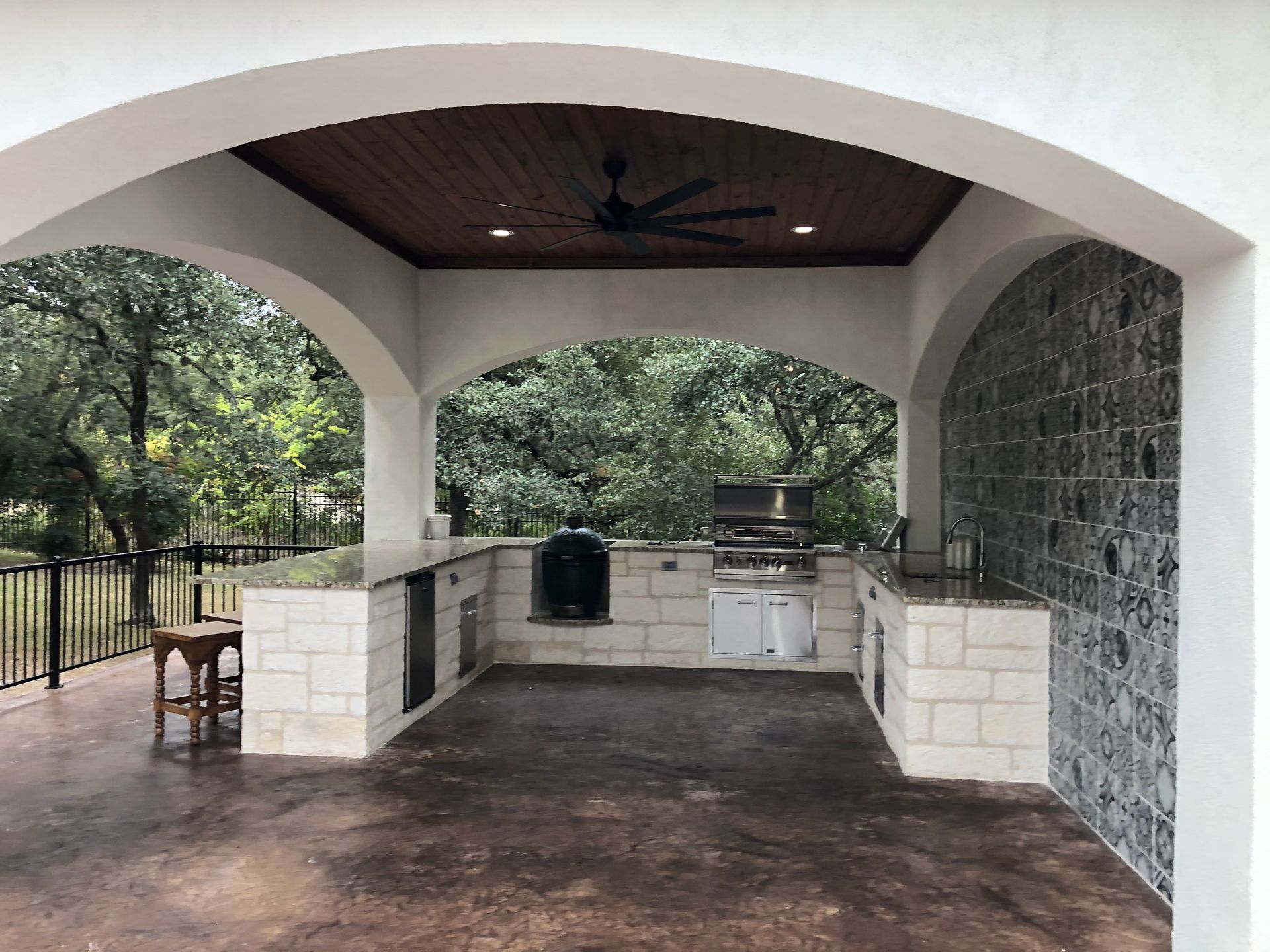 A large outdoor kitchen with a ceiling fan built by Fine Patio Design San Antonio TX