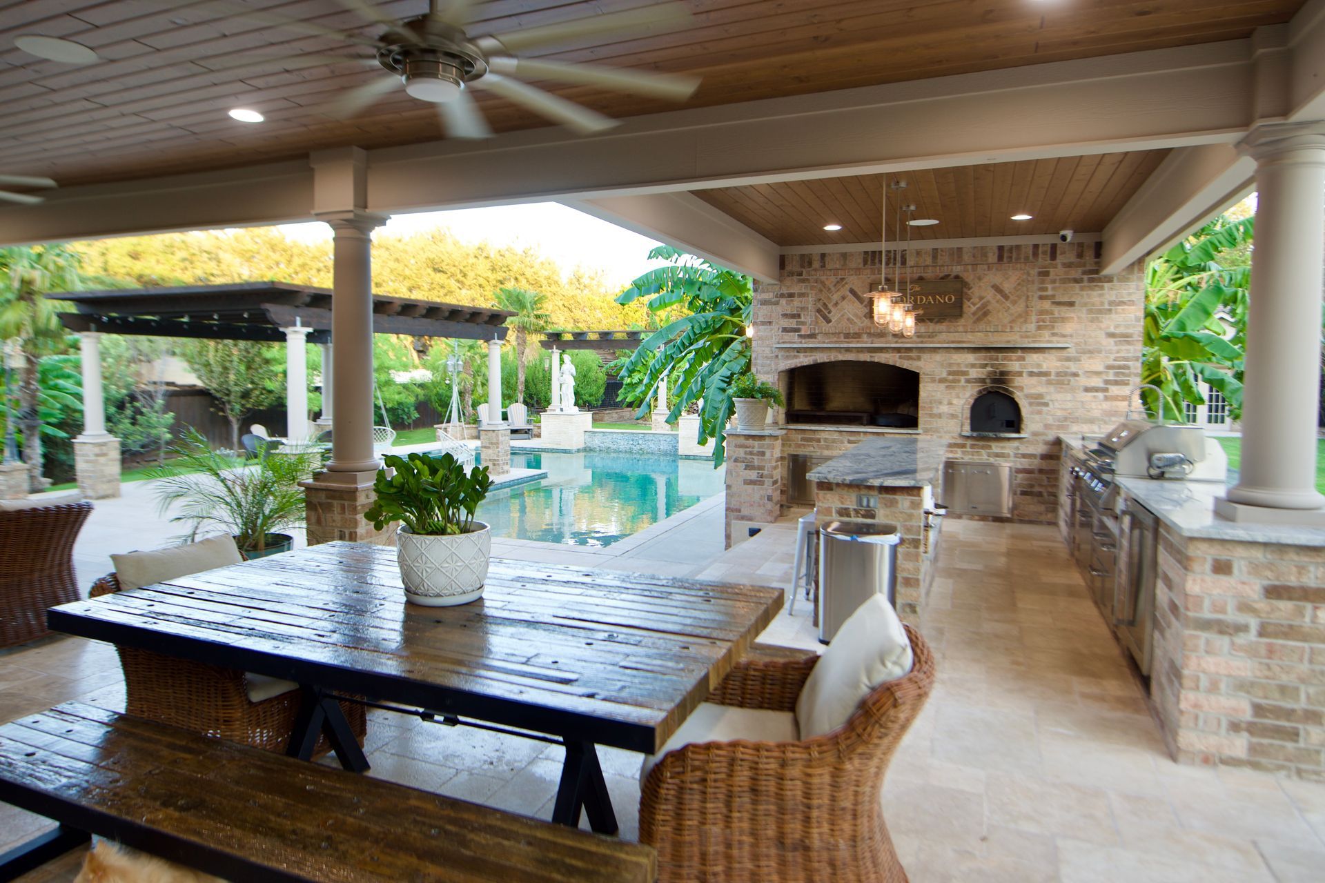 A patio with a table and chairs and a ceiling fan built by Fine Patio Design San Antonio TX