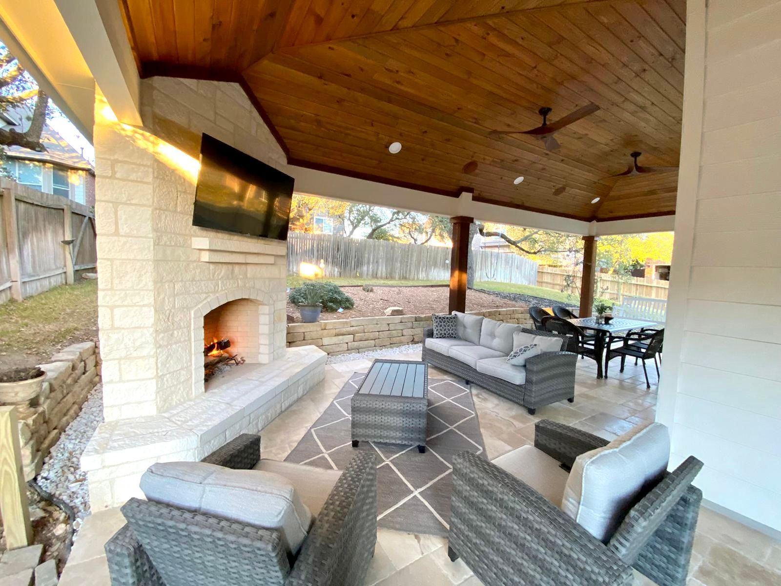 A living room with a fireplace and a flat screen tv built by Fine Patio Design San Antonio TX