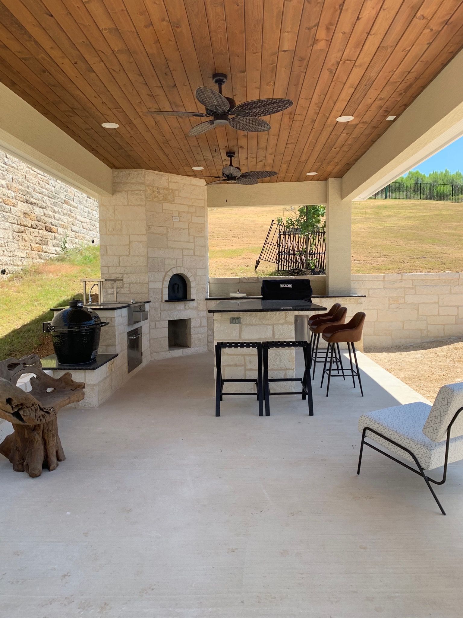 A large outdoor kitchen with a ceiling fan built by Fine Patio Design San Antonio TX