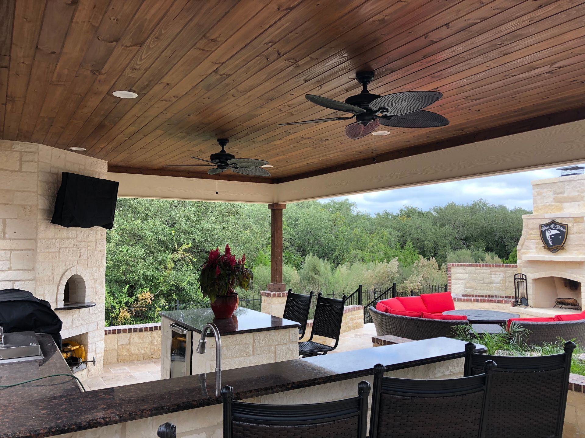 A ceiling fan is hanging from the ceiling of a patio area built by Fine Patio Design San Antonio TX