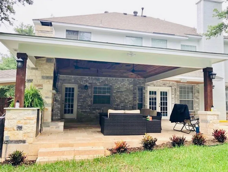 A large house with a large covered patio area in front of it built by Fine Patio Design San Antonio TX