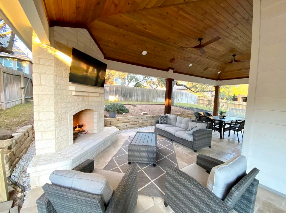 A living room with a fireplace , couch , chairs and a television built by Fine Patio Design San Antonio TX