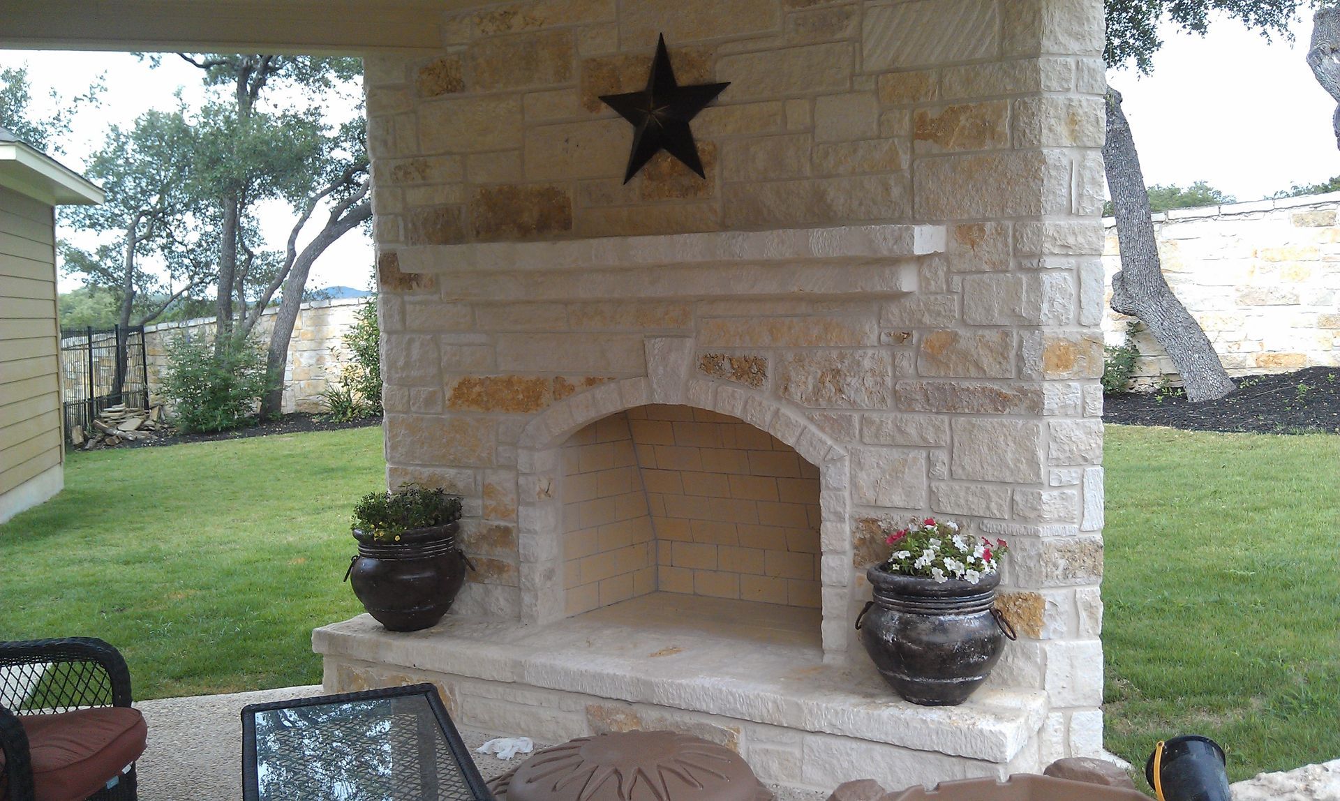 A stone fireplace with a star on top of it built by Fine Patio Design San Antonio TX