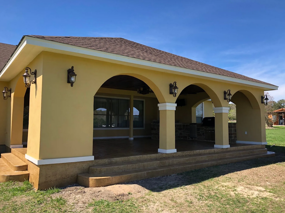 A yellow house with arches on the side of it built by Fine Patio Design San Antonio TX