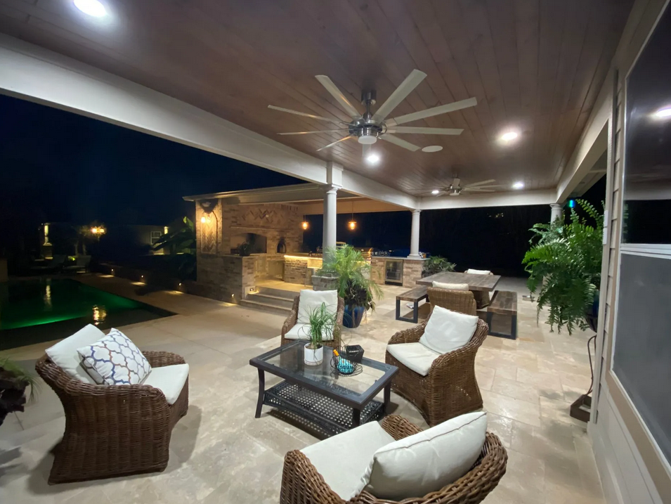 A patio with wicker furniture and a ceiling fan built by Fine Patio Design San Antonio TX