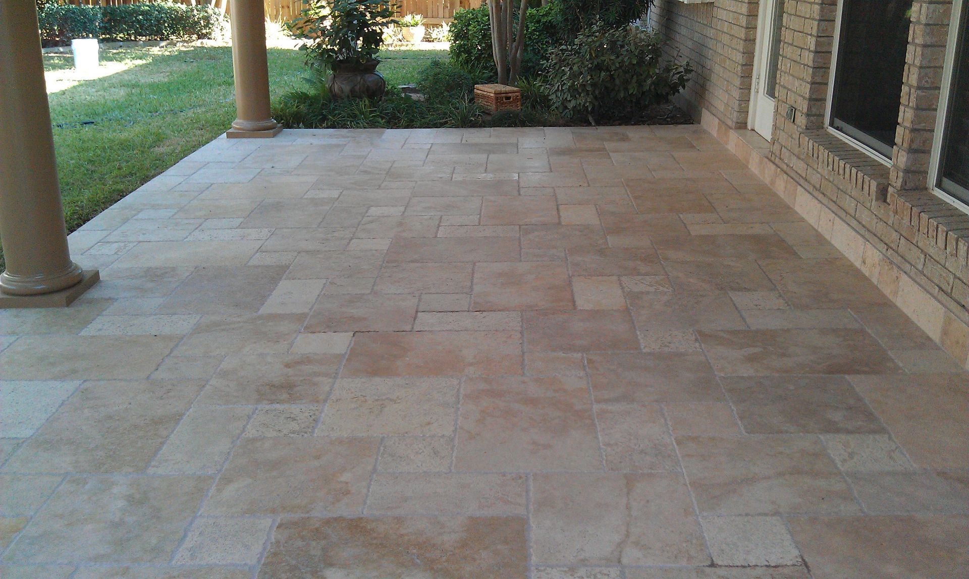 A brick building with a decorative concrete patio in front of it built by Fine Patio Design San Antonio TX