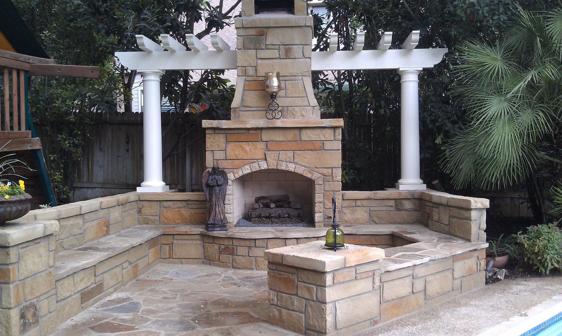 A fireplace with a bottle of wine in front of it built by Fine Patio Design San Antonio TX