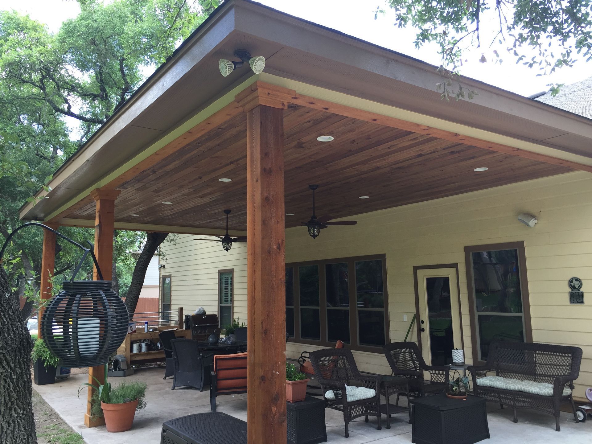 A house with a covered porch with a ceiling fan built by Fine Patio Design San Antonio TX