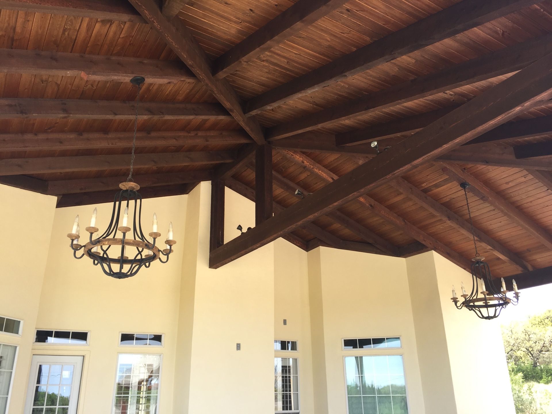 A wooden ceiling with a chandelier hanging from it built by Fine Patio Design San Antonio TX