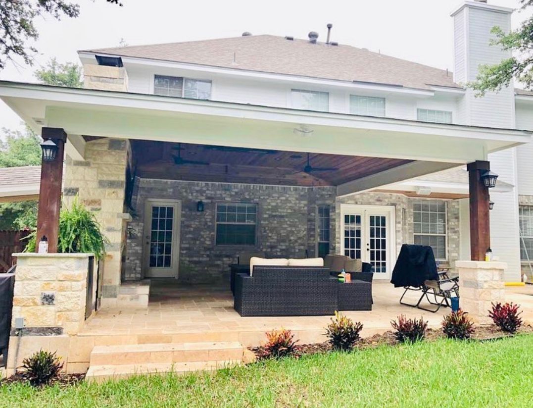 A large house with a large covered patio area in front of it built by Fine Patio Design San Antonio TX
