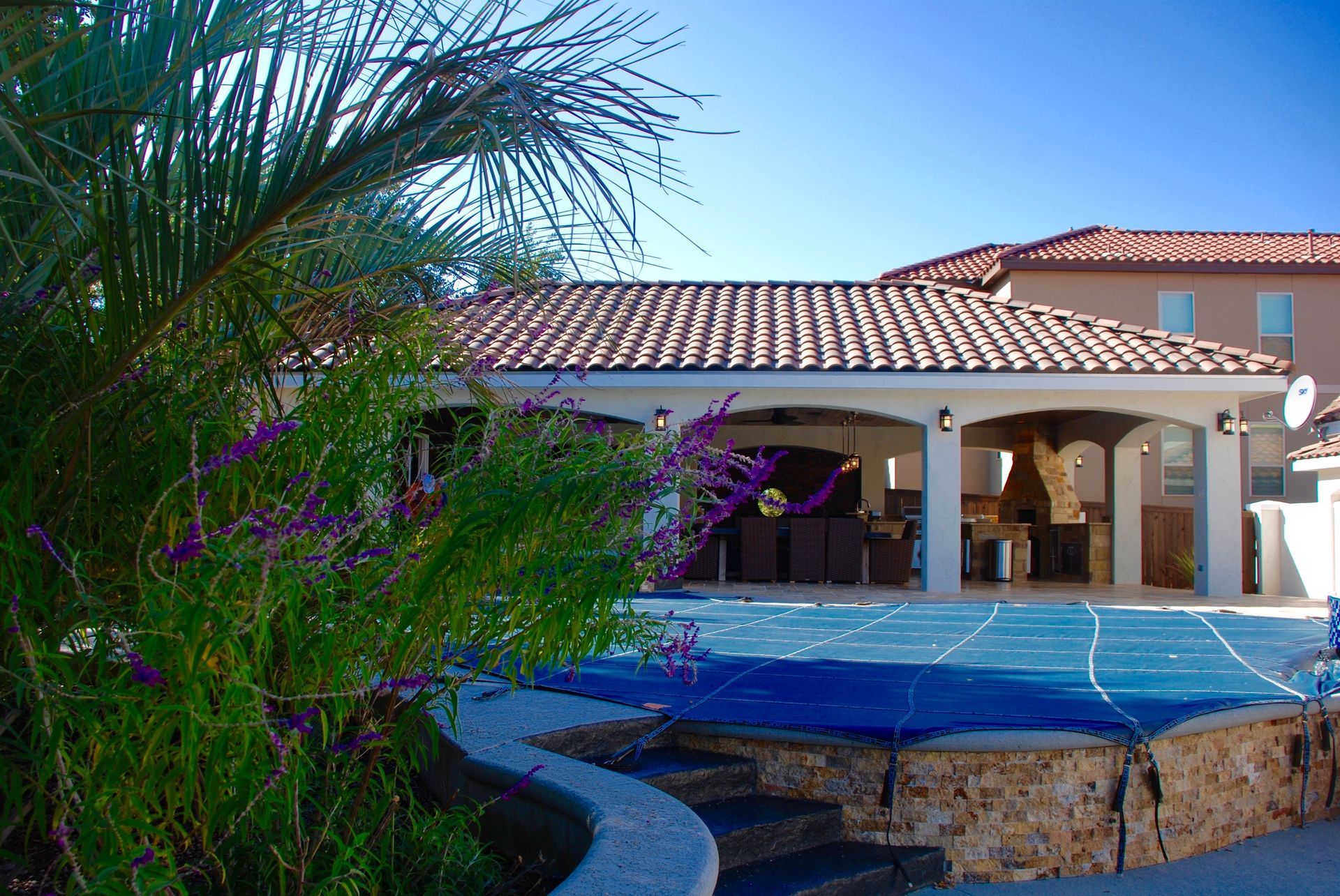 A large house with a swimming pool in front of it built by Fine Patio Design San Antonio TX