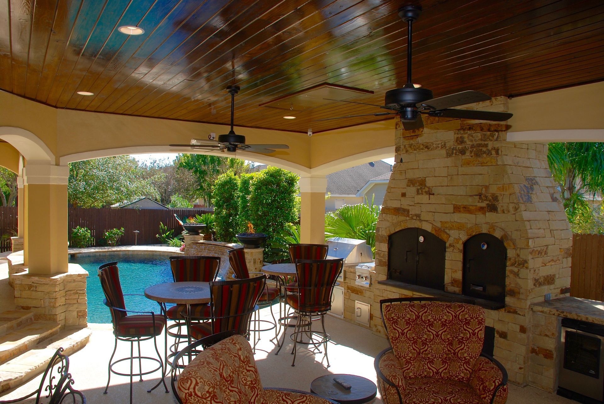 A patio area with tables and chairs and a fireplace built by Fine Patio Design San Antonio TX
