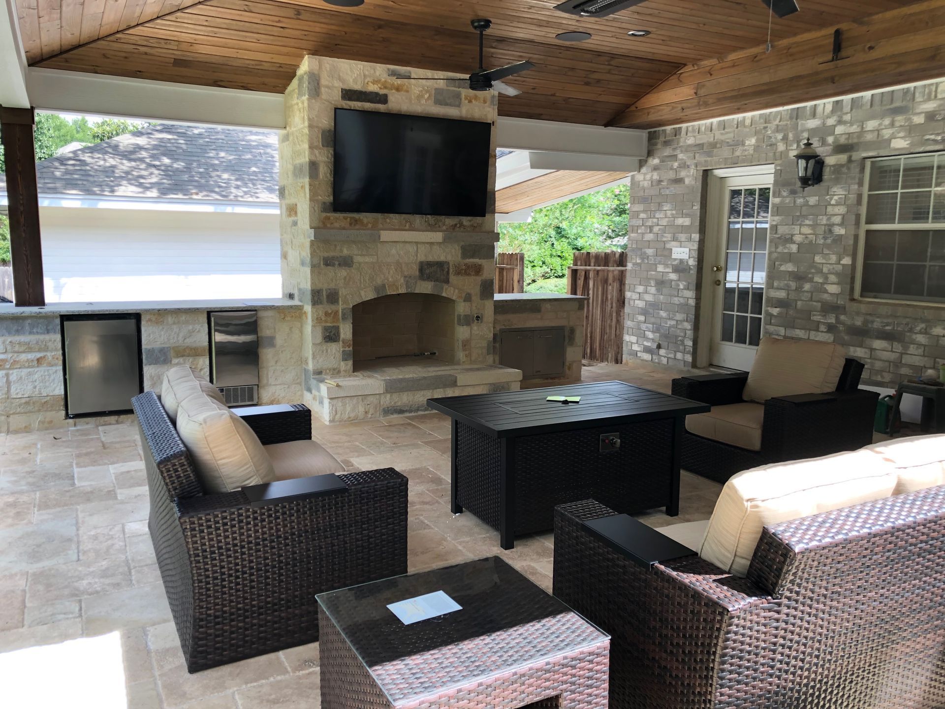 A living room with wicker furniture and a flat screen tv built by Fine Patio Design San Antonio TX