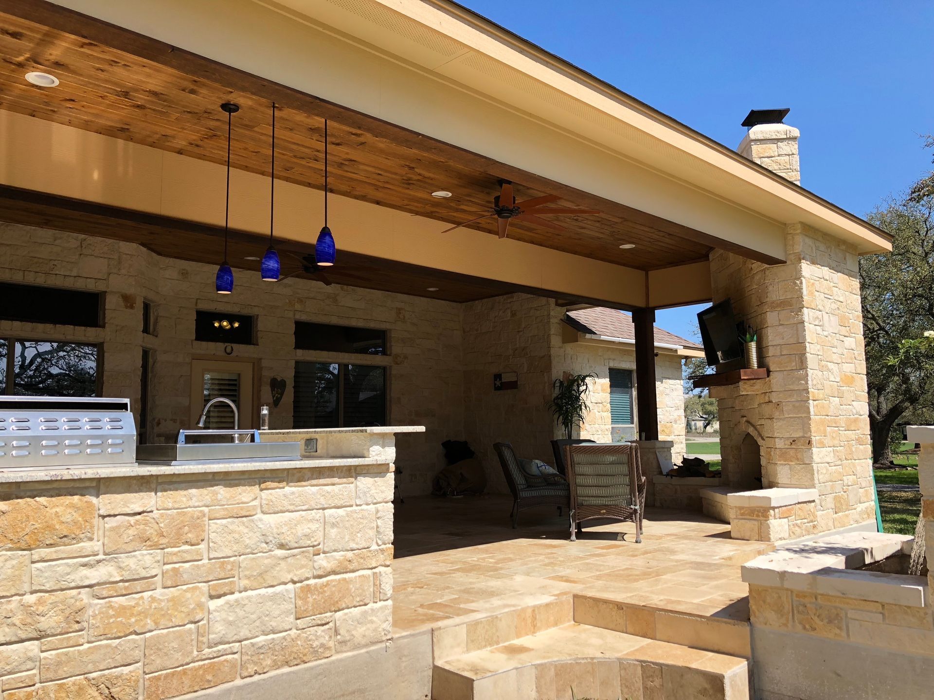 A house with a covered patio and a kitchen built by Fine Patio Design San Antonio TX 