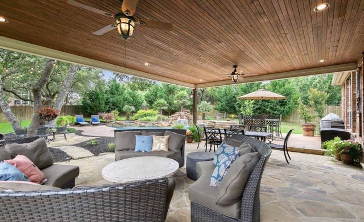 A patio with a lot of furniture and a ceiling fan built by Fine Patio Design San Antonio TX 