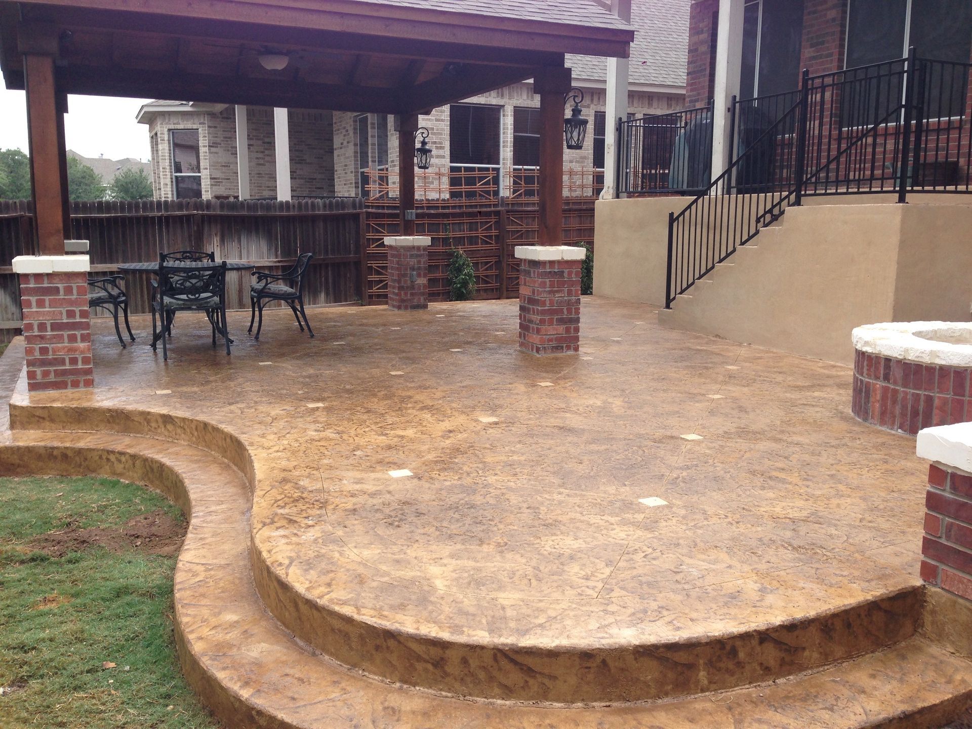 A patio with a table and chairs under a pergola built by Fine Patio Design San Antonio TX
