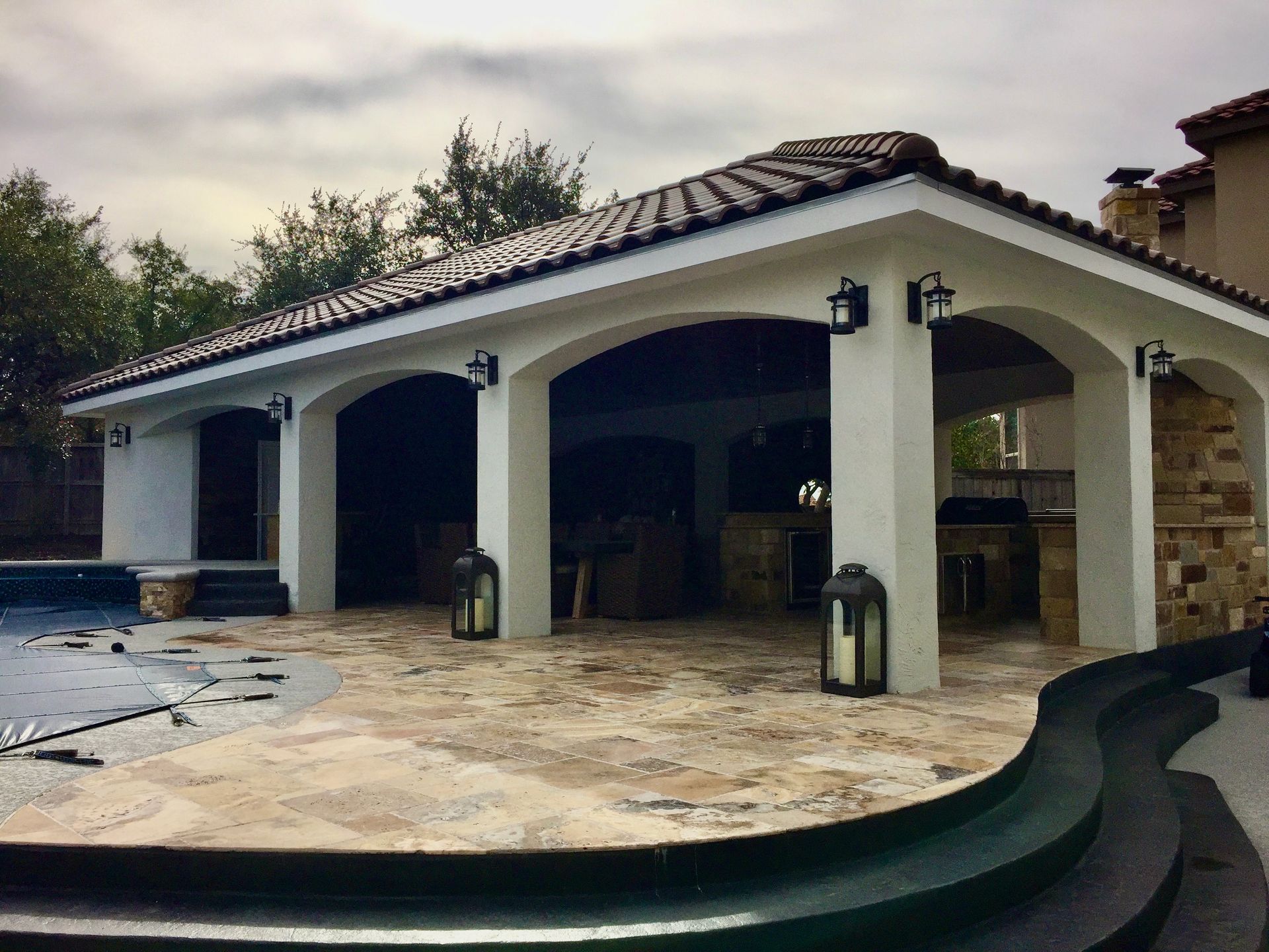 A white house with a tiled roof and arches built by Fine Patio Design San Antonio TX