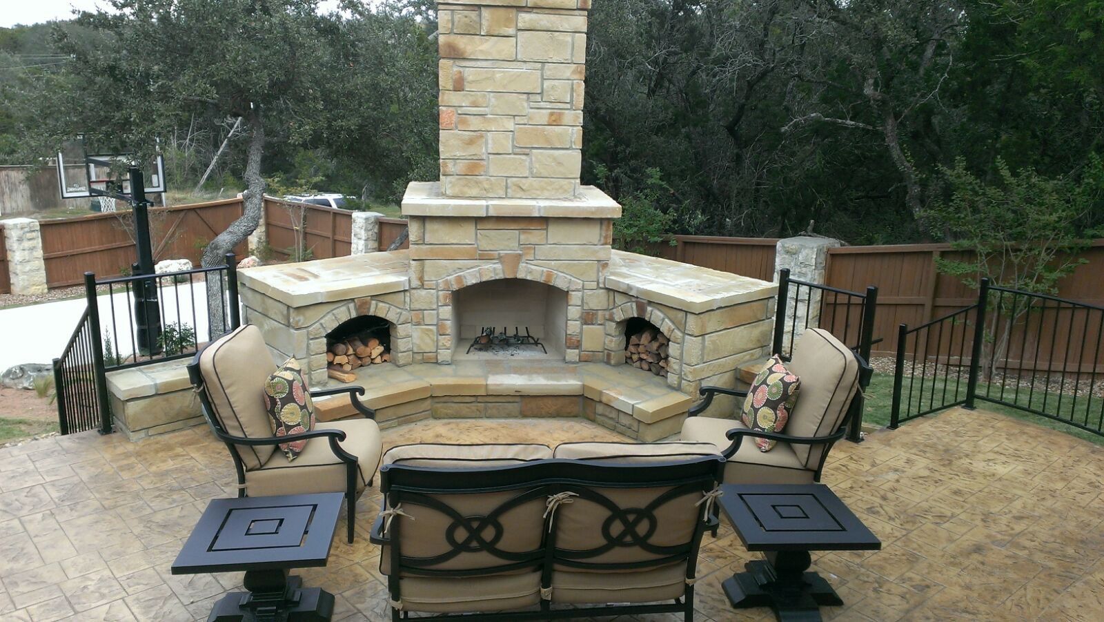 A stone fireplace with a couch and chairs in front of it built by Fine Patio Design San Antonio TX