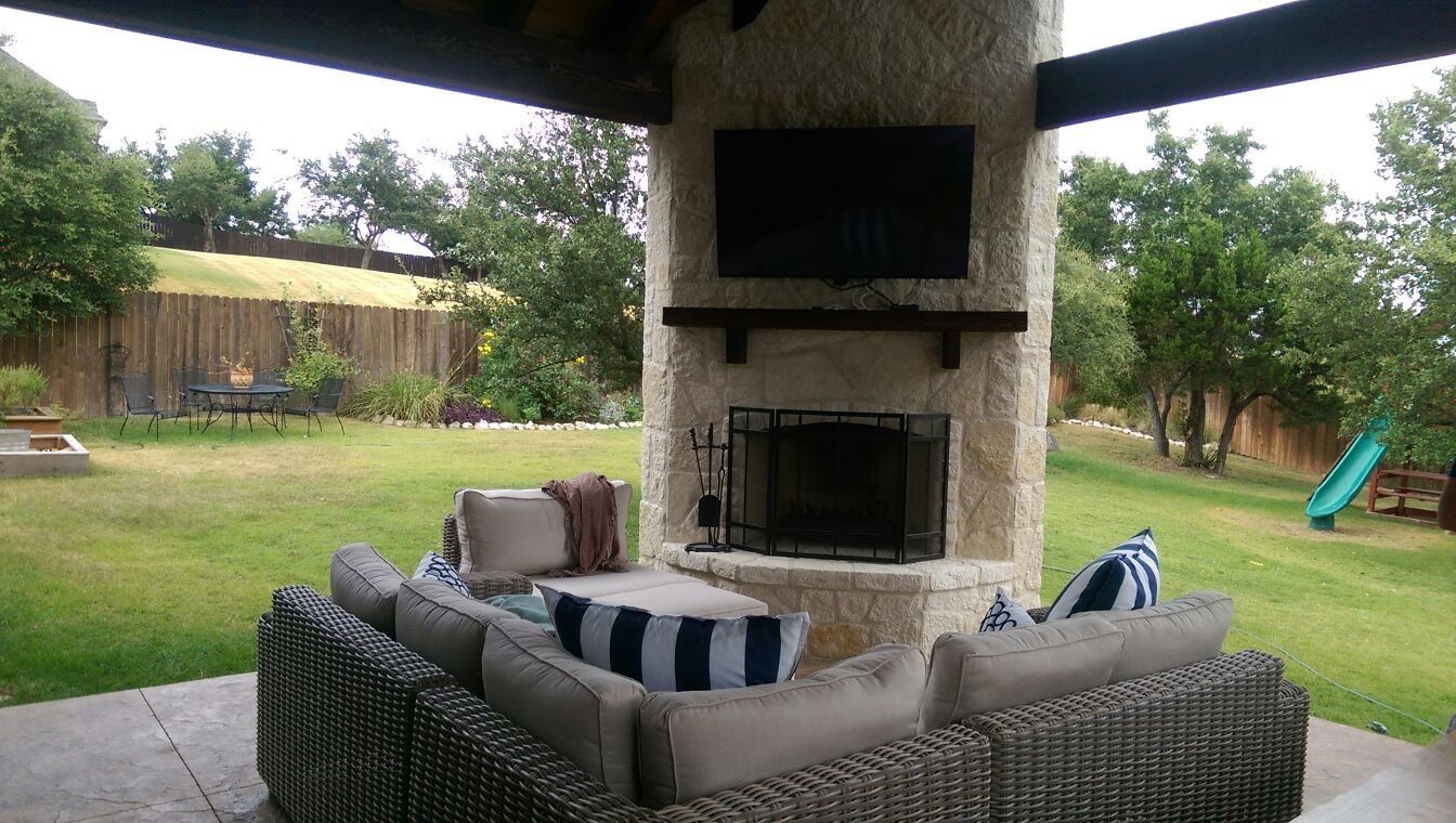 A living room with a fireplace and a flat screen tv built by Fine Patio Design San Antonio TX