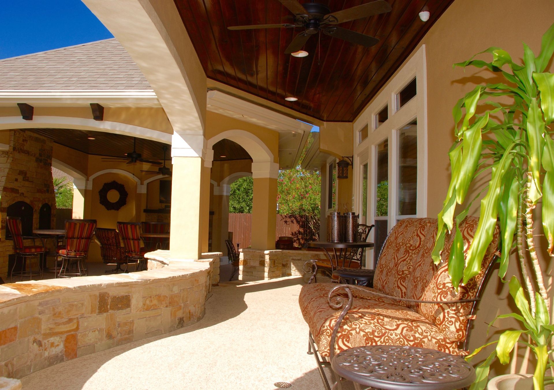 A patio with a couch and chairs and a ceiling fan built by Fine Patio Design San Antonio TX