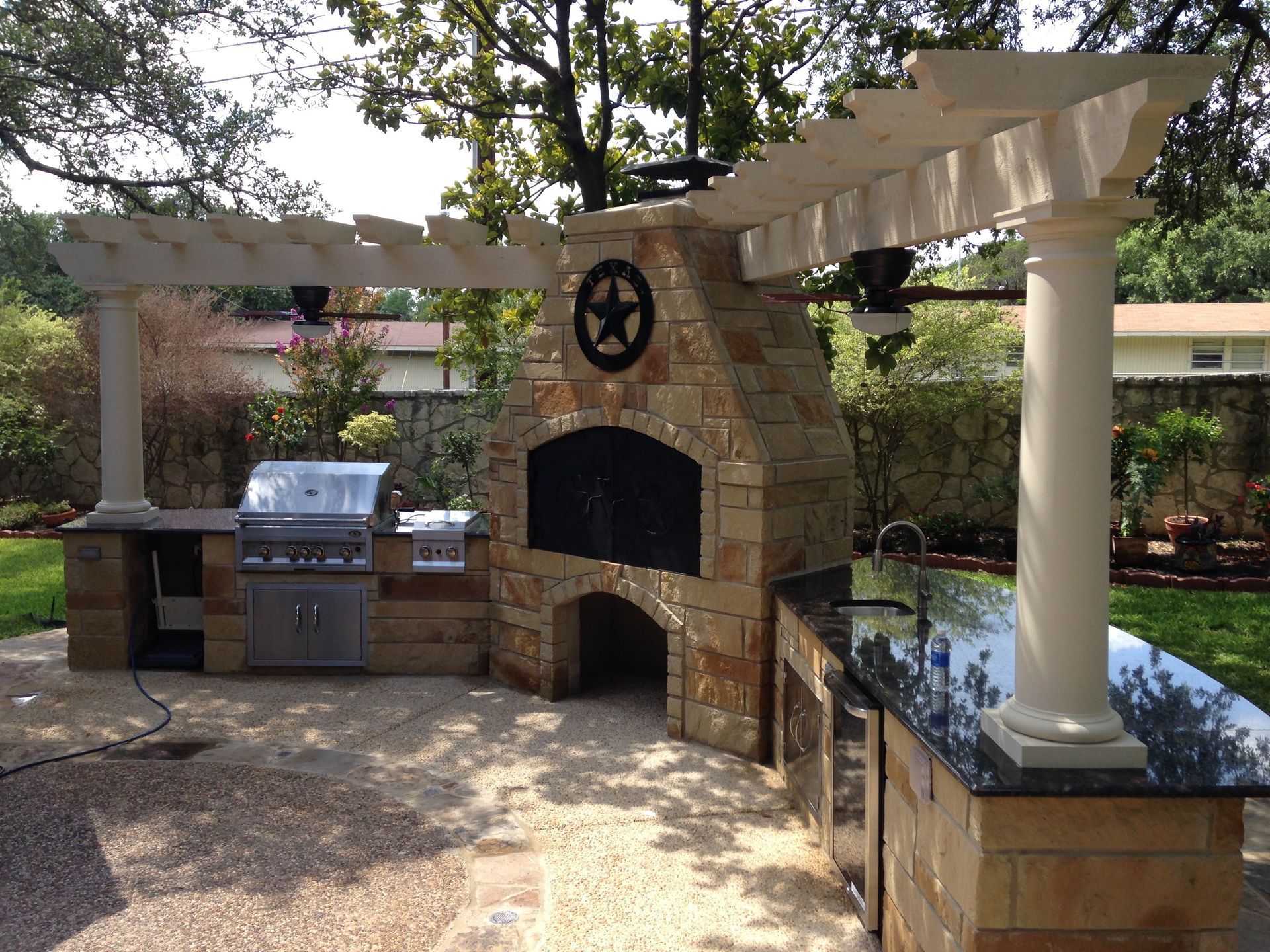 An outdoor kitchen with a Texas star on it built by Fine Patio Design San Antonio TX