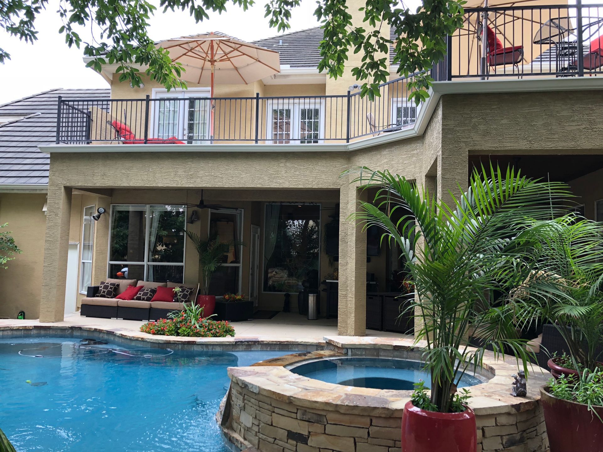 A large house with a swimming pool and a balcony built by Fine Patio Design San Antonio TX