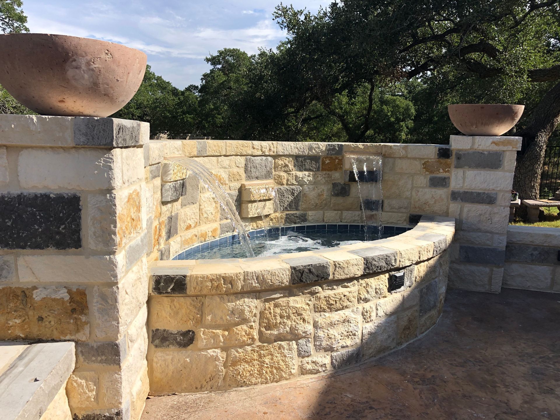 A brick wall with a water feature in it built by Fine Patio Design San Antonio TX