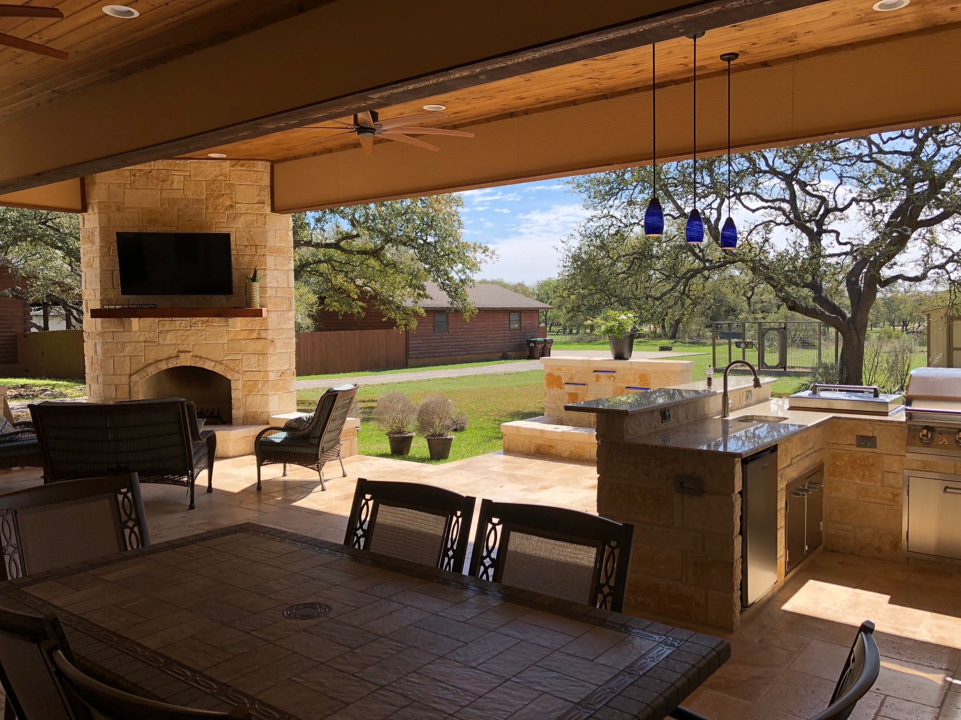 A patio with a table and chairs and a fireplace built by Fine Patio Design San Antonio TX
