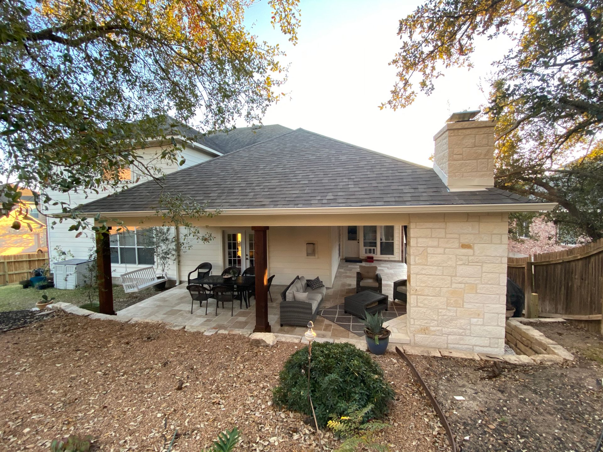 A house with a covered patio and a chimney built by Fine Patio Design San Antonio TX