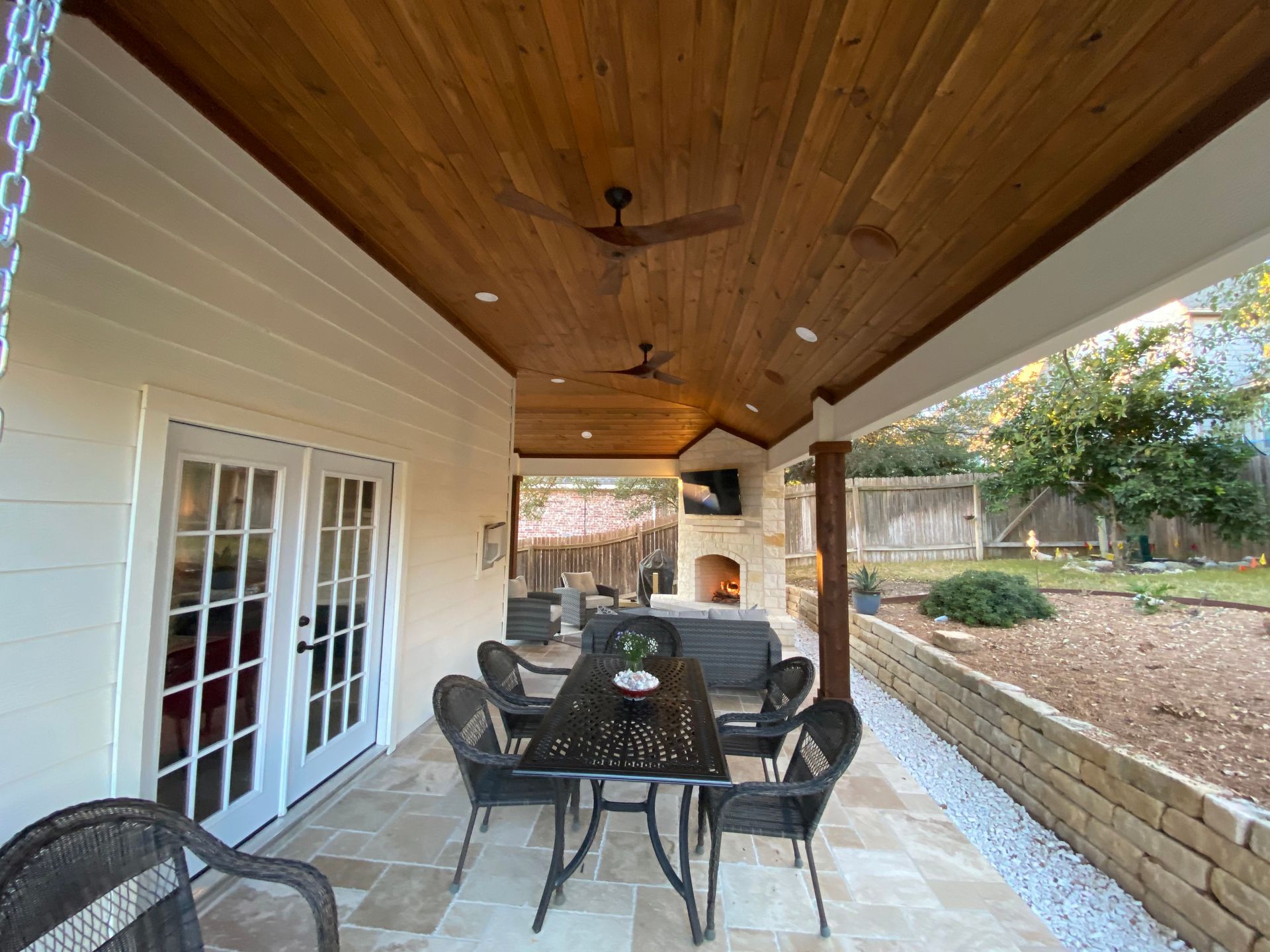 A patio with a table and chairs and a ceiling fan built by Fine Patio Design San Antonio TX