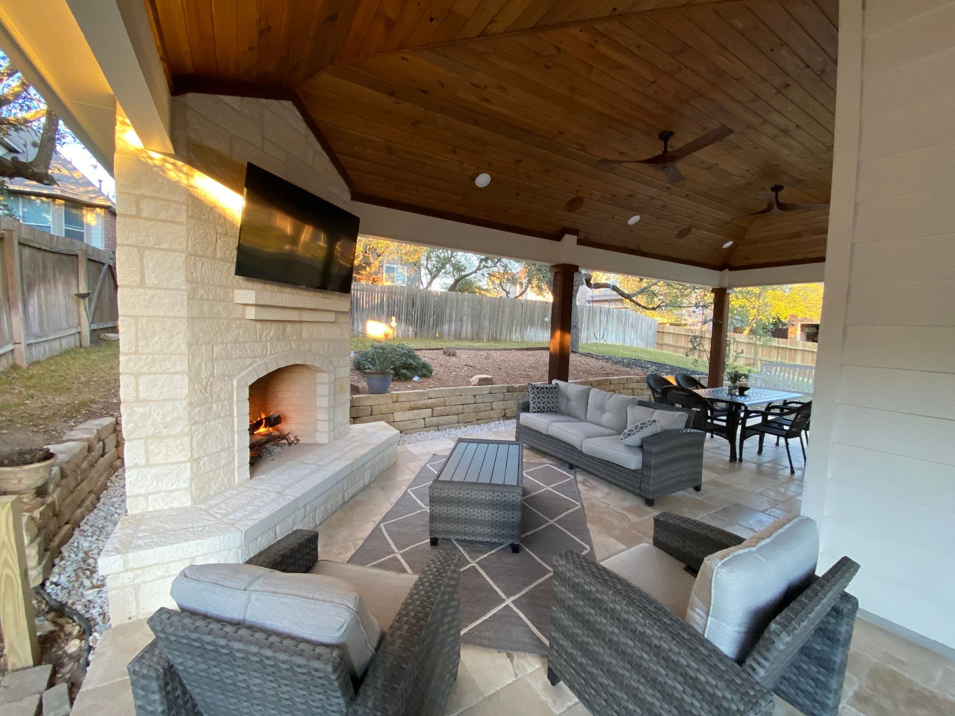 A patio with wicker furniture and a fireplace built by Fine Patio Design San Antonio TX