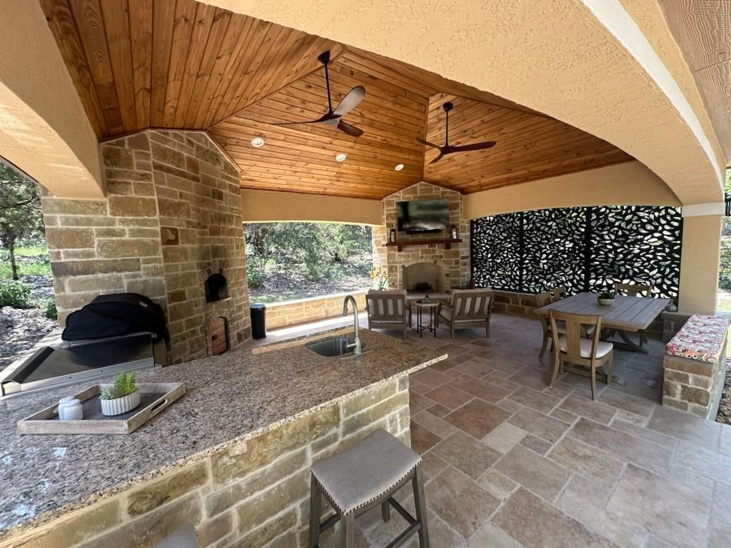 A patio with a table and chairs and a ceiling fan built by Fine Patio Design San Antonio TX