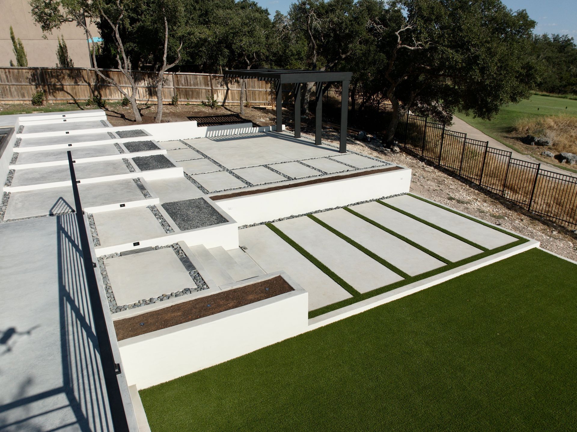 A backyard with a fence and a few steps built by Fine Patio Design San Antonio TX
