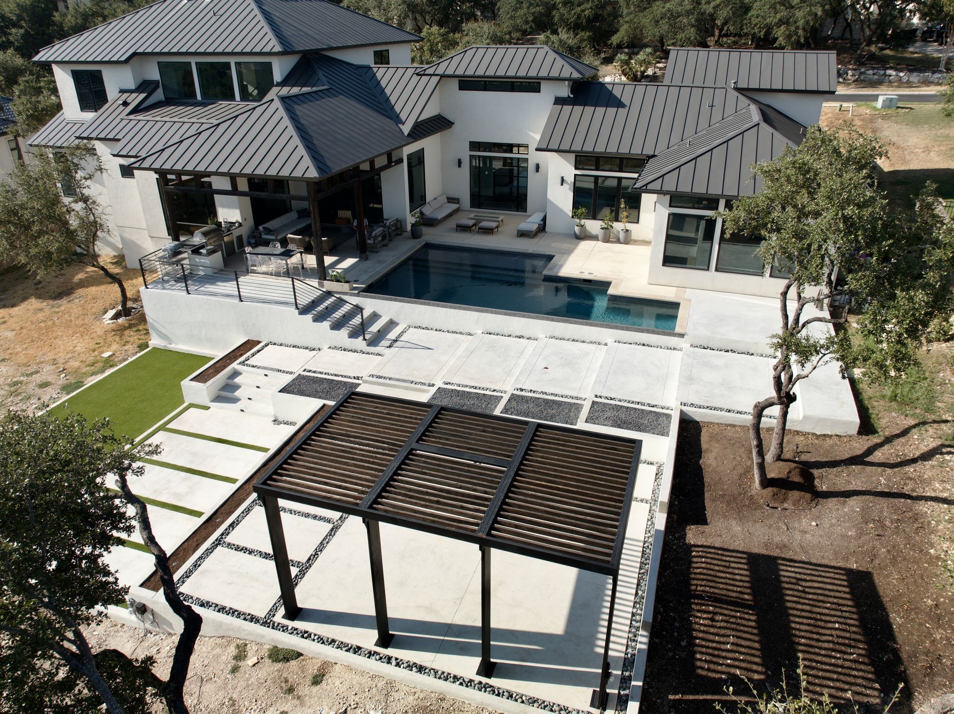 An aerial view of a house with a large swimming pool built by Fine Patio Design San Antonio TX