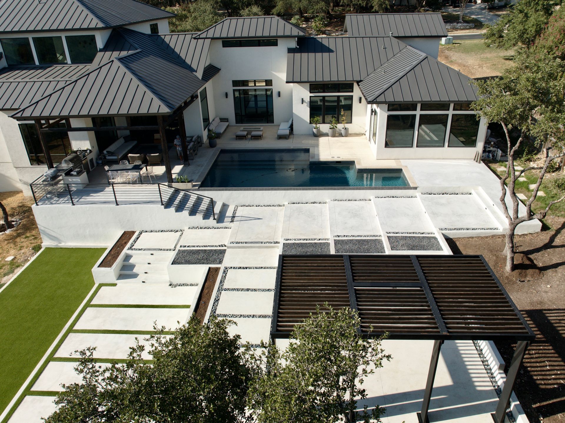 An aerial view of a house with a large swimming pool built by Fine Patio Design San Antonio TX