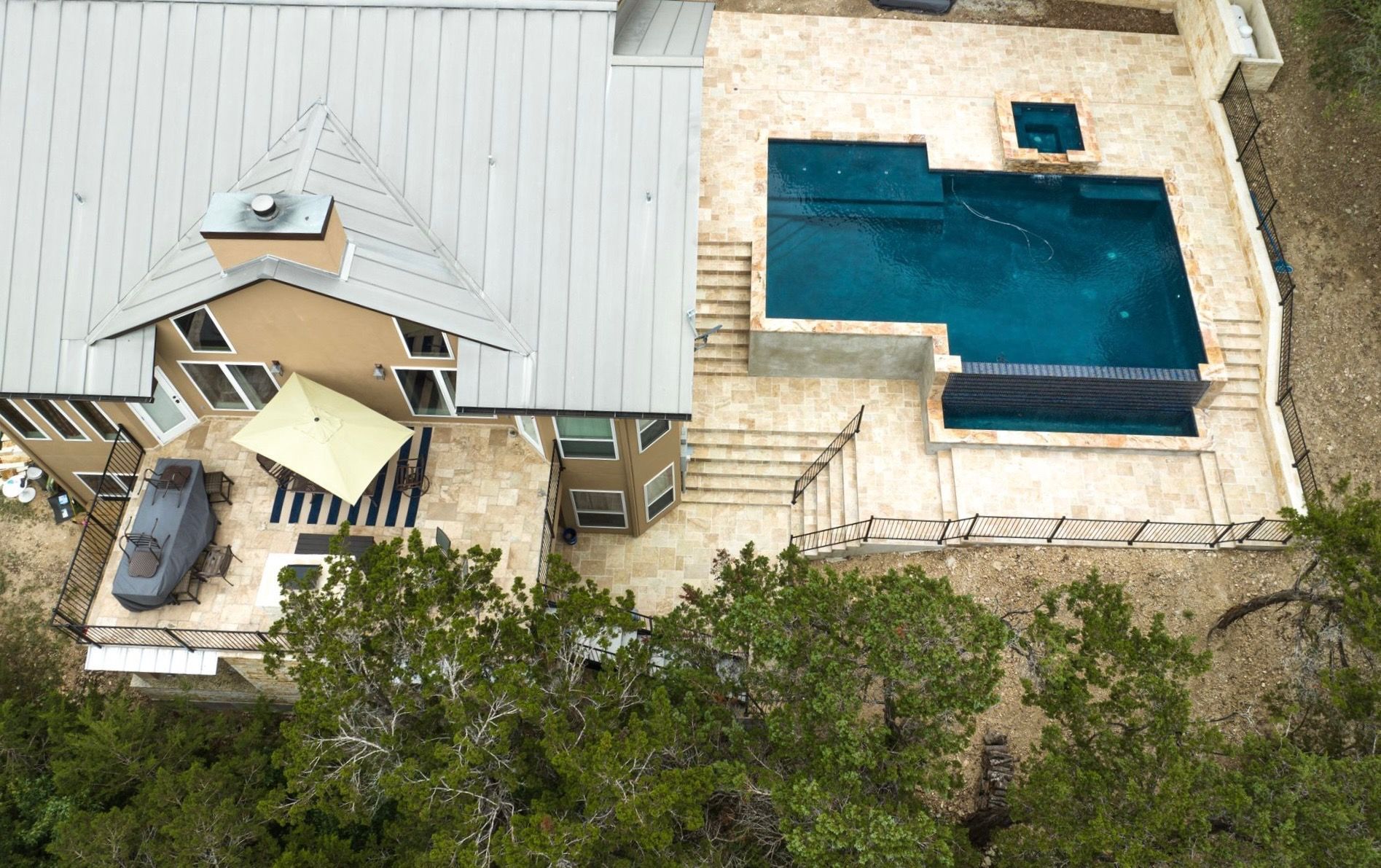 An aerial view of a house with a large swimming pool designed by Fine Patio Design San Antonio TX