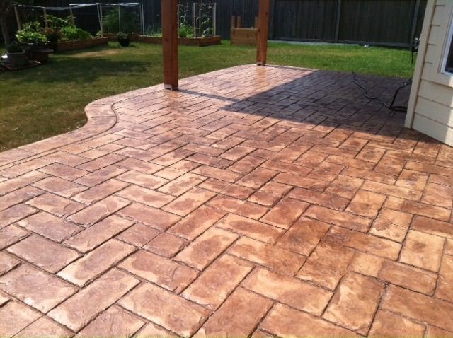 A concrete patio with a herringbone pattern on it built by Fine Patio Design San Antonio TX