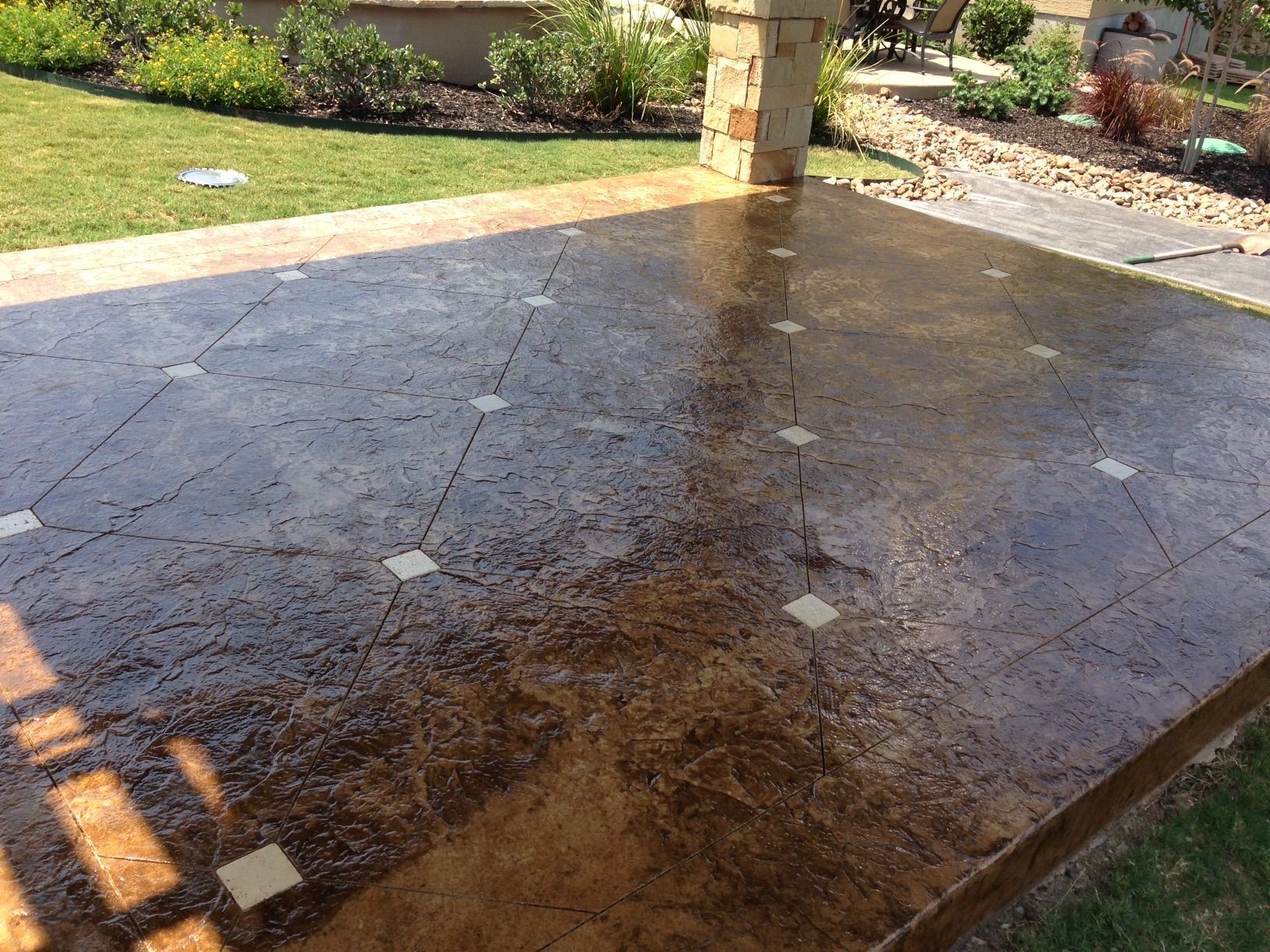 Decorative concrete surface with a few white squares on it built by Fine Patio Design San Antonio TX