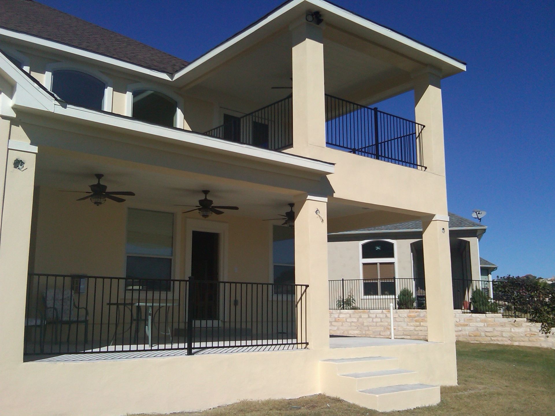 A large house with a large porch and stairs built by Fine Patio Design San Antonio TX